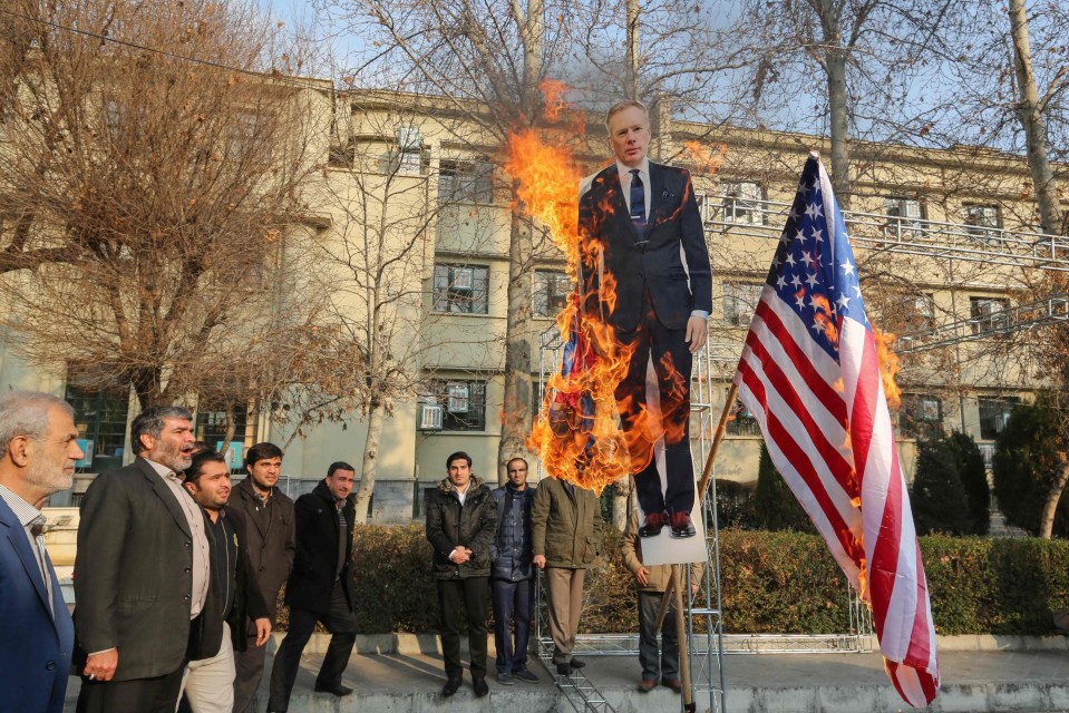 Pro-regime protesters burn a cutout of UK ambassador Rob Macaire in Tehran today