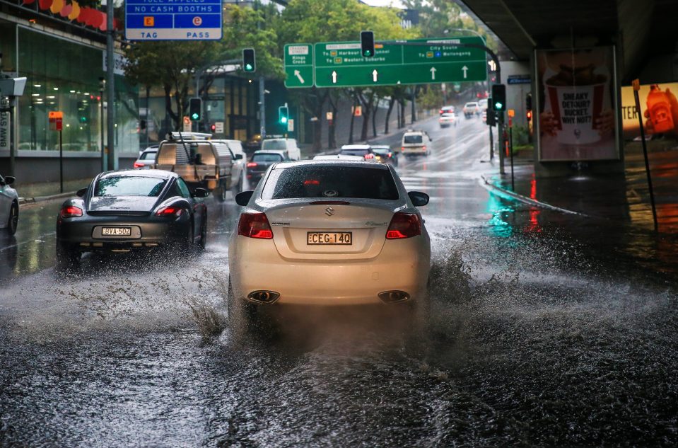  Cars drive through a flooded underpass in Sydney's business district today