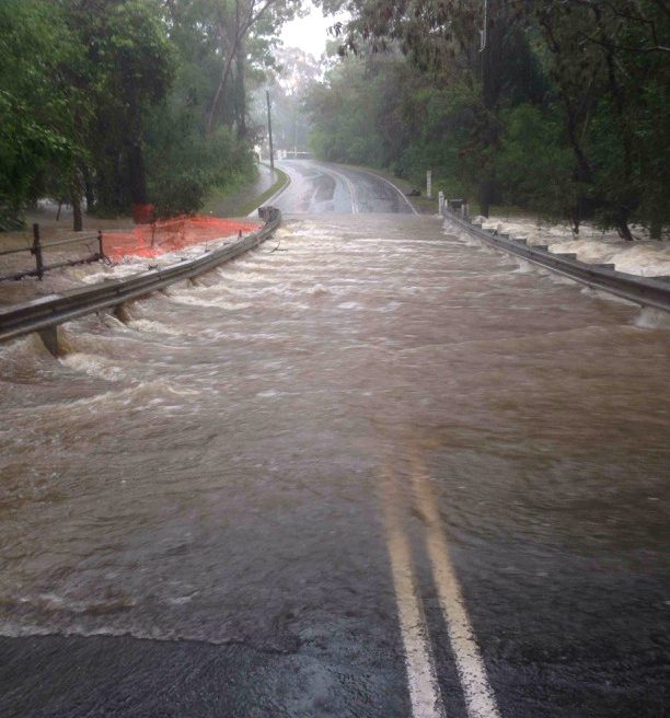  A flash flood streams across a road making it impassable