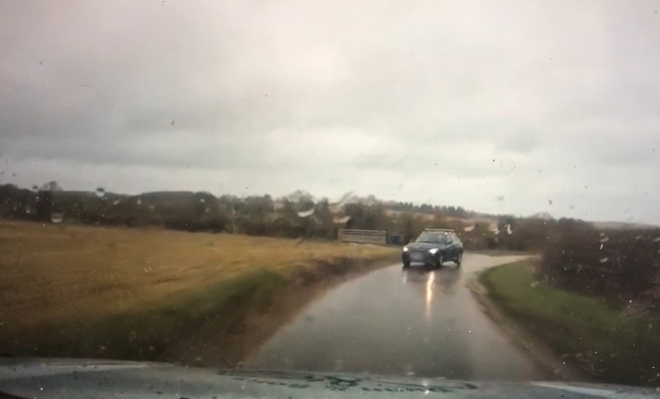  The blue car takes the blind corner on the wrong side of the road