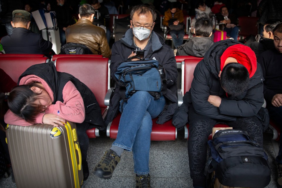 A traveler wears a face mask as he sits in a waiting room at the Beijing West Railway Station