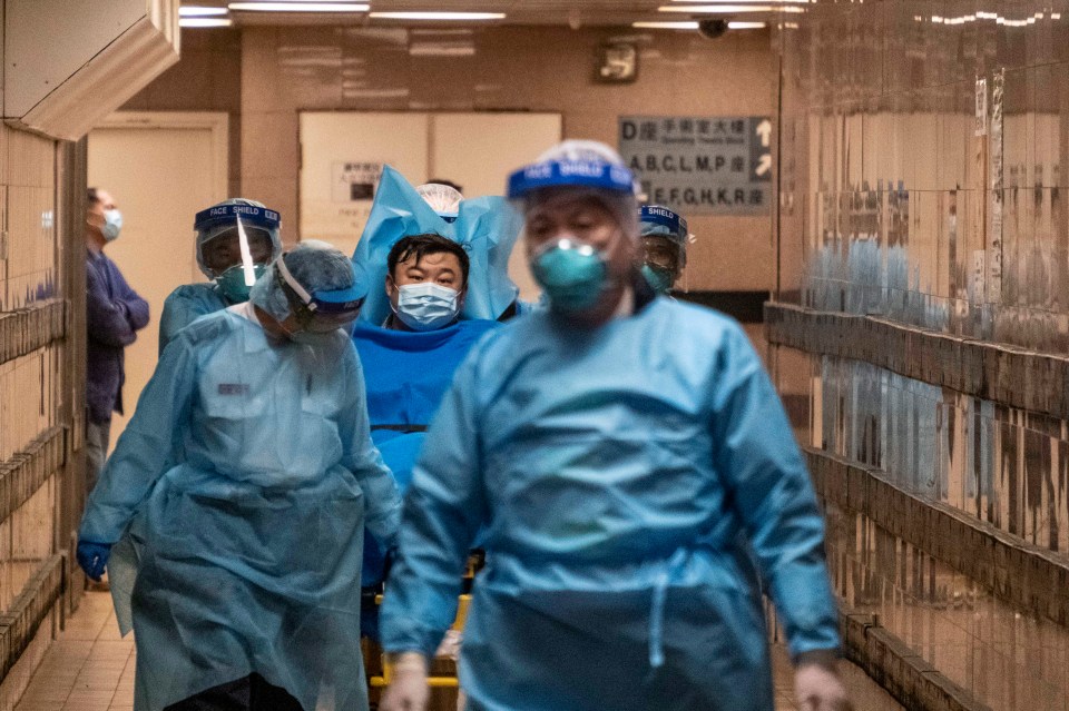 Paramedics transport a man believed to be Hong Kong's first Wuhan coronavirus patient to a hospital