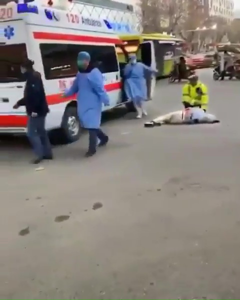  Emergency services wearing masks and protective clothing tend to an individual who appeared to collapse on the street