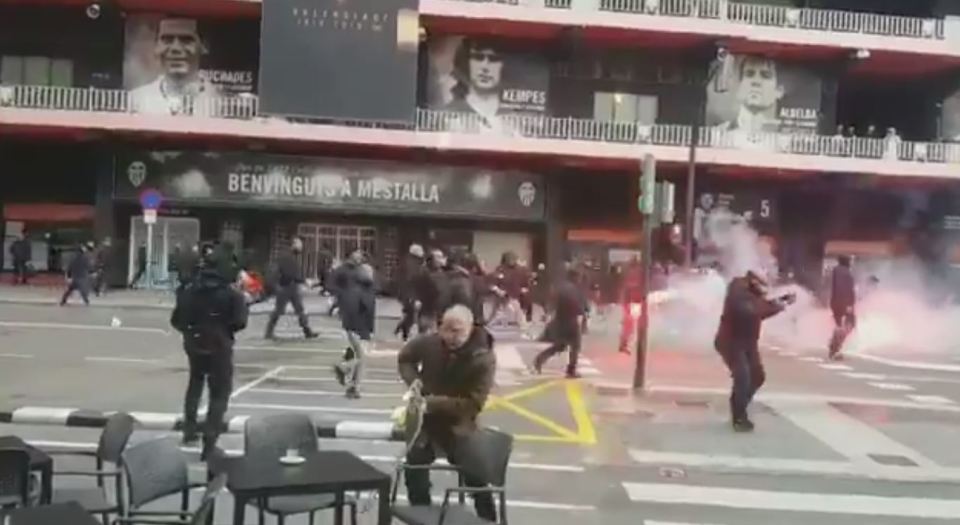  One man collects a plate from a table as a potential weapon