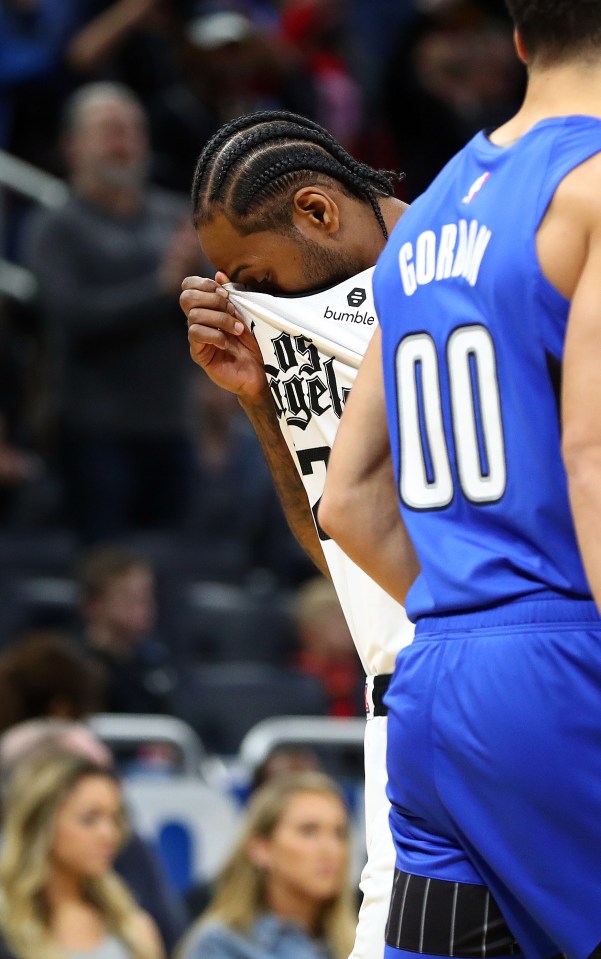 Los Angeles Clippers player Kawhi Leonard covers his face upon hearing about Bryant's death