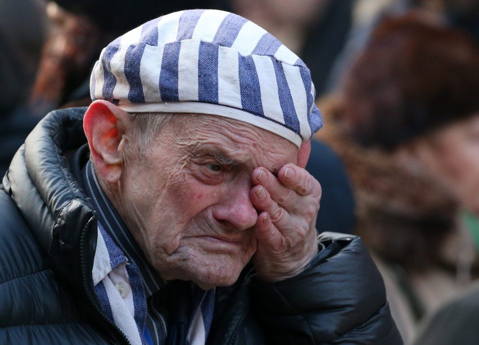  One man wearing a camp uniform sobs during a ceremony to lay flowers