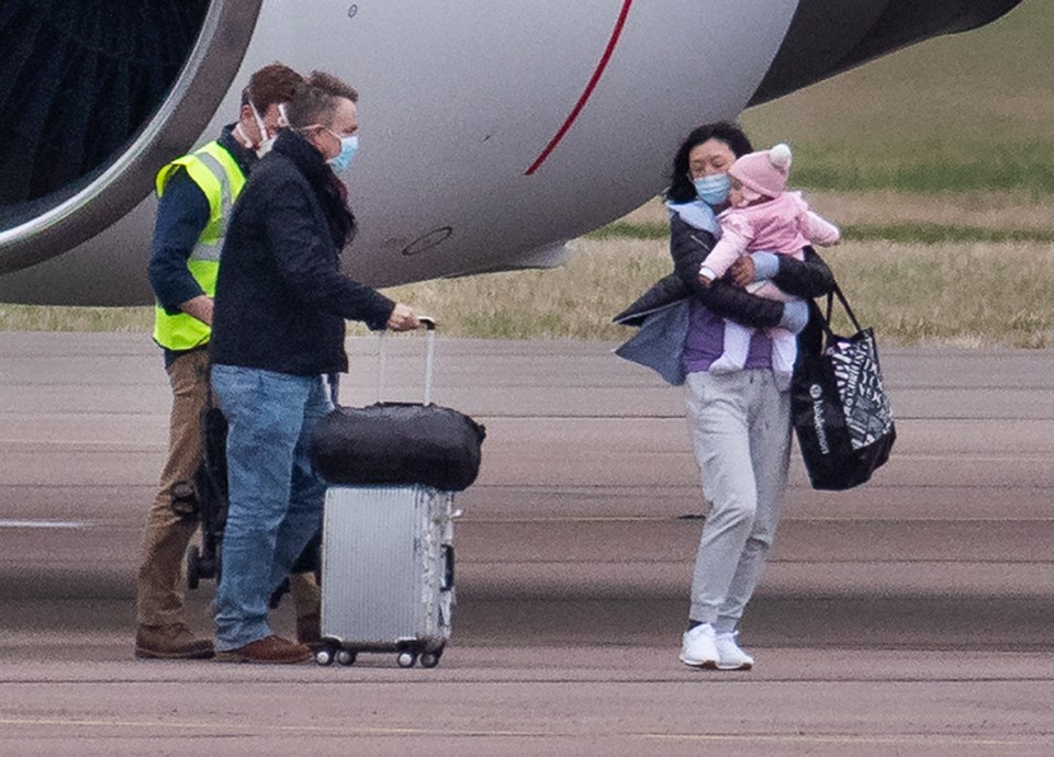  A mum carried a young girl after the Brits touched down in Oxfordshire