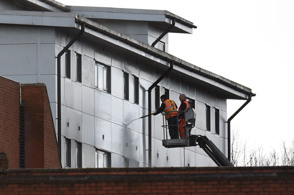  Workers use a pressure cleaner to wash the front of accommodation blocks to house British nationals evacuated from Wuhan