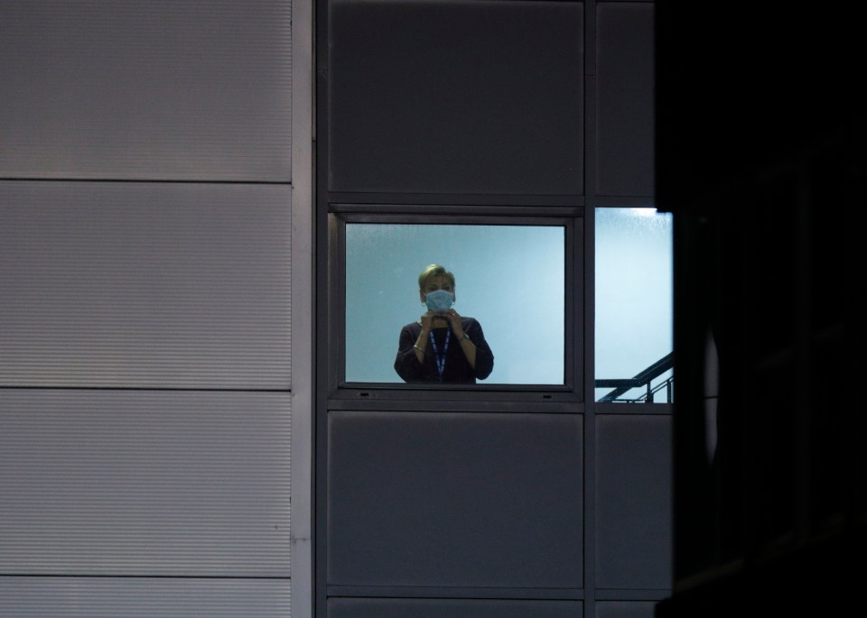  A member of medical staff wearing a protective mask at the NHS hospital looks on as the passengers arrive