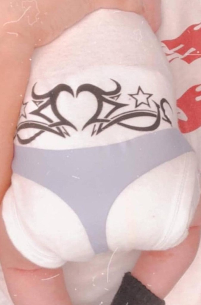 The reverse is printed with a "tramp stamp" tattoo above the "thong"