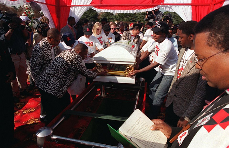  Pallbearers lower the coffin of Nkosi Johnson, aged 12, who died of the virus that causes AIDS