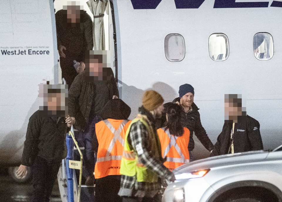  Prince Harry is escorted by security as he arrives in Canada