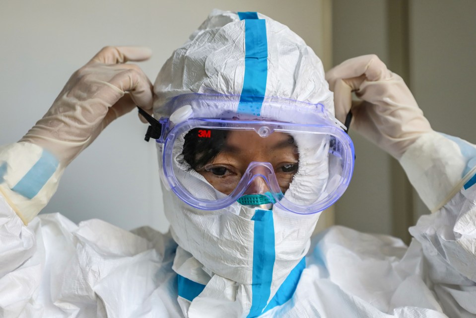 Medical staff puts on protective clothing before gong into the infected ward