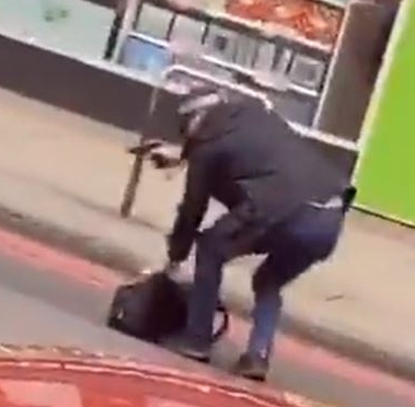  An armed police officer holding a gun as he picked up a bag from the road