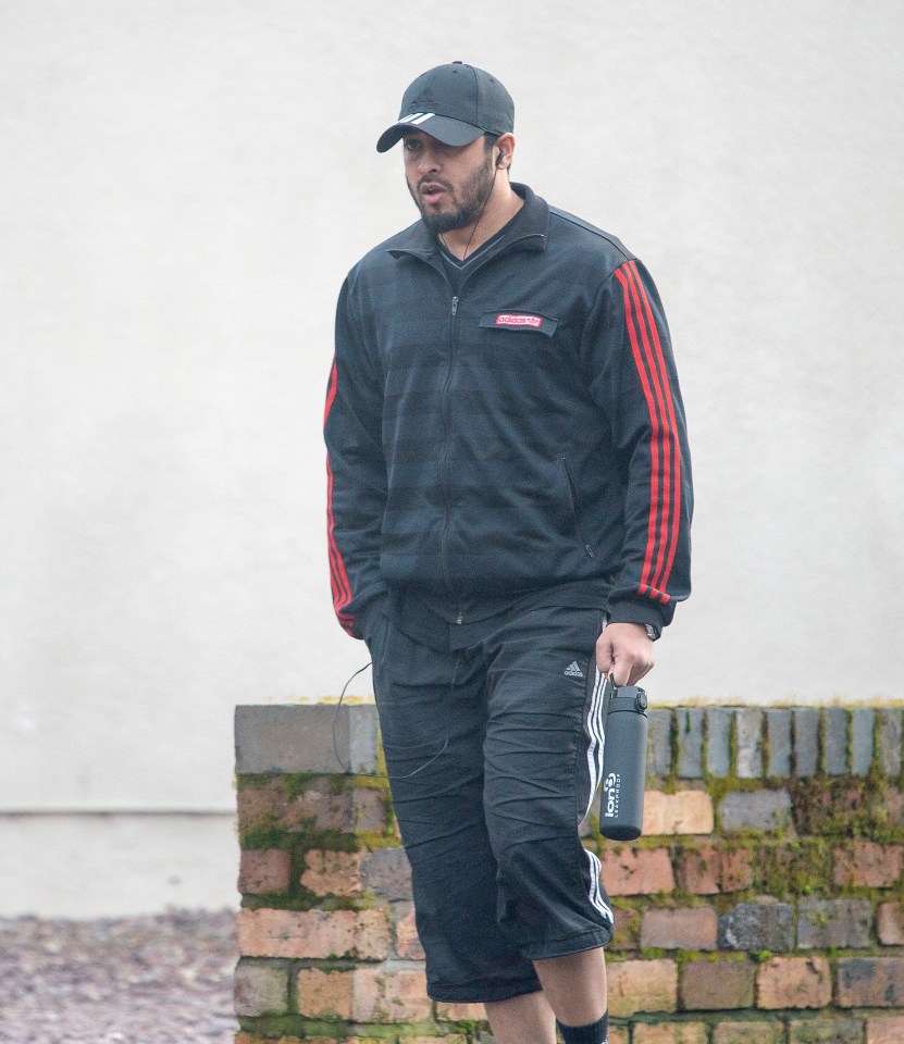  Shahjahan listens to headphones as he strolls to the gym for a workout