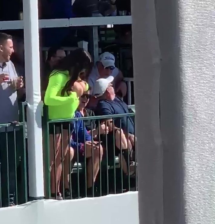  The woman pulled down her neon green shirt to distract the players putting on the green