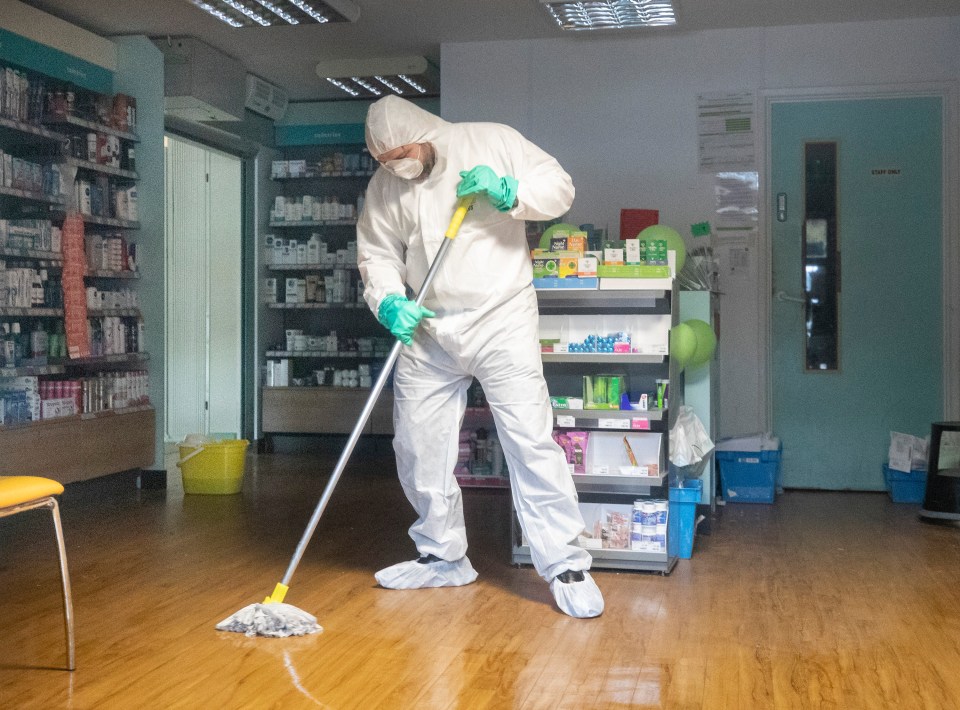 A man in a hazmat suit mops the floor of the County Oak Medical Centre in Brighton