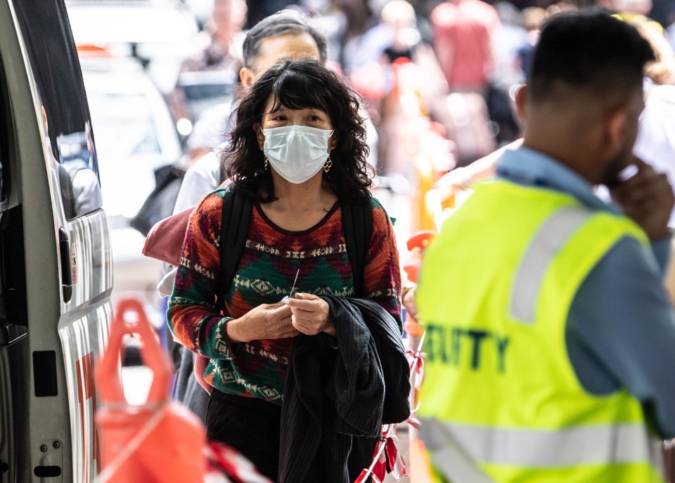  A woman wearing a face mask seen near the Overseas Passenger Terminal near where the cruise ship docked at Circular Quay in Sydney