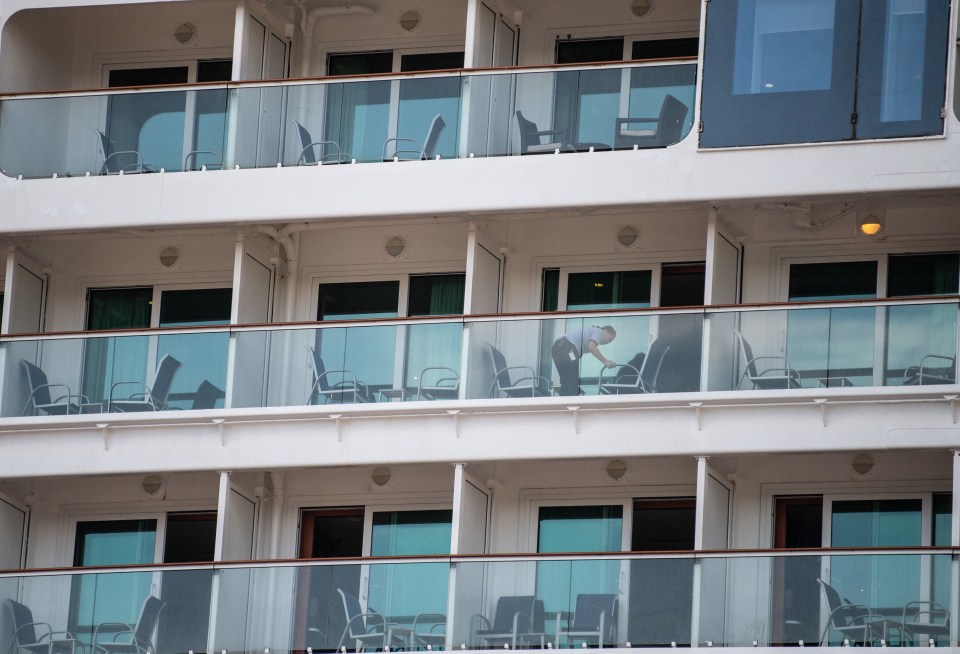  A crew member cleans a balcony on board the Norwegian Jewel cruise ship