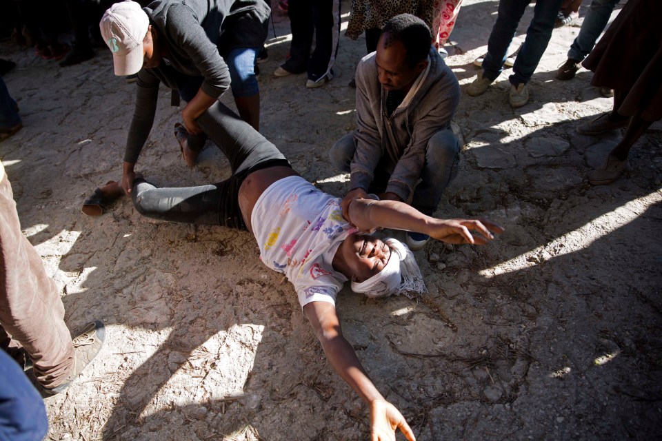  A pregnant woman cries after discovering her twin children died in a fire at the orphanage