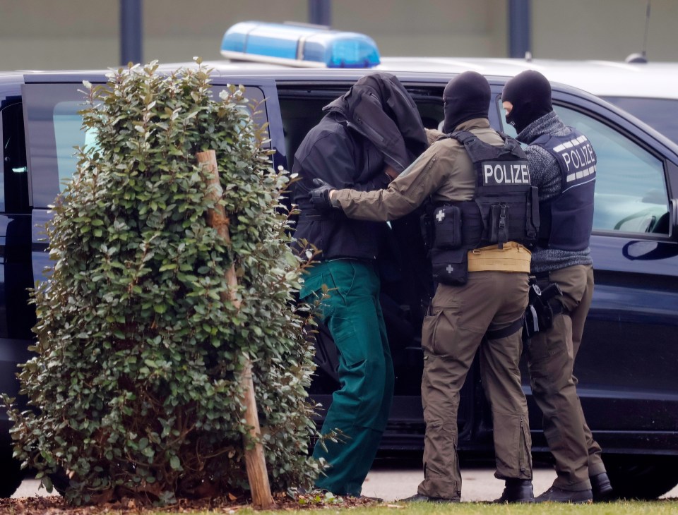  Federal Police officers escort a man suspected of terrorism to his arraignment at the Federal Supreme Court in Karlsruhe, Germany