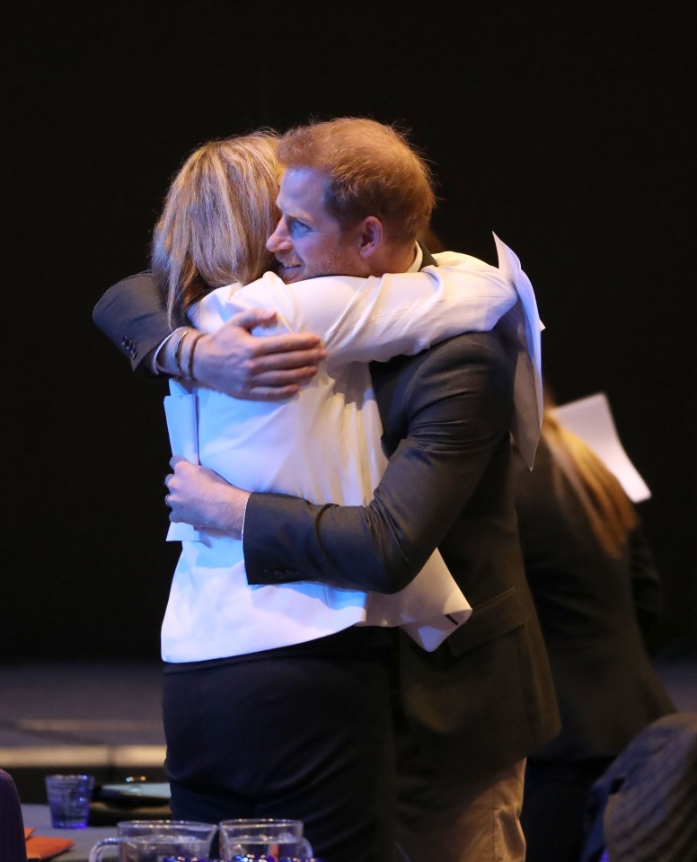  Prince Harry hugs one of the guests at the Edinburgh conference