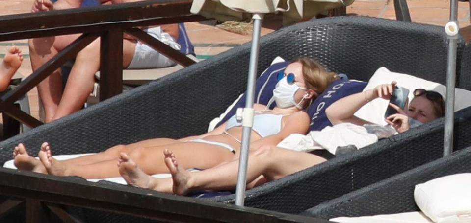 Guests at the H10 Costa Adeje Palace who have been told to self-isolate in their rooms after an Italian couple were diagnosed with the bug are pictured lounging by the pool