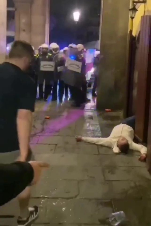  A Wolves fan lies unconscious after scuffles with police in Barcelona last night