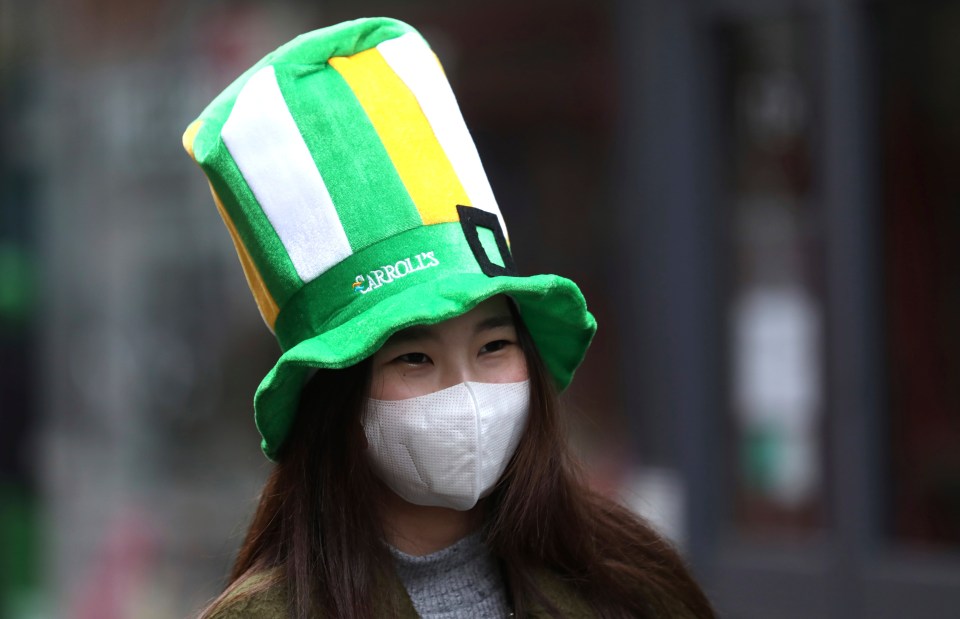  Tourists protect themselves while walking through the empty streets of Dublin