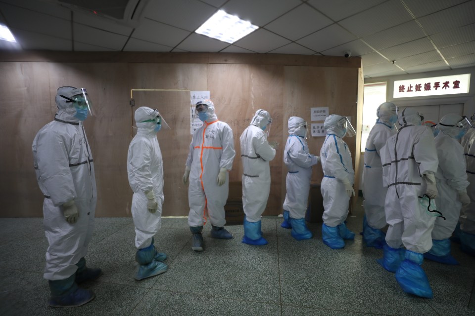 Medical staff in isolation gowns prepare to enter the isolation zone in a hospital designated for COVID-19 patients in Wuhan