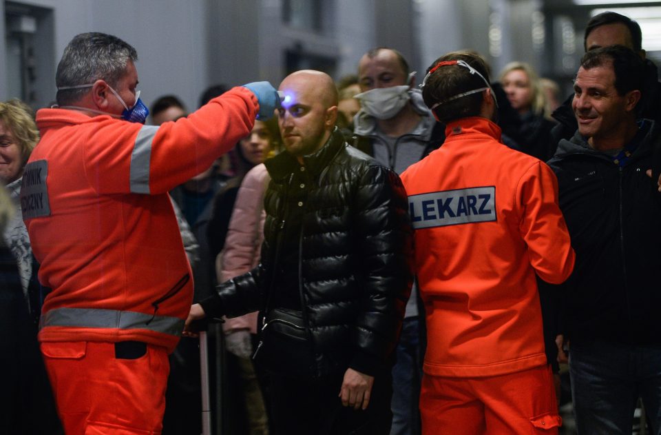  A healthworker screens a passenger arriving from Milan, Italy to Krakow, Poland