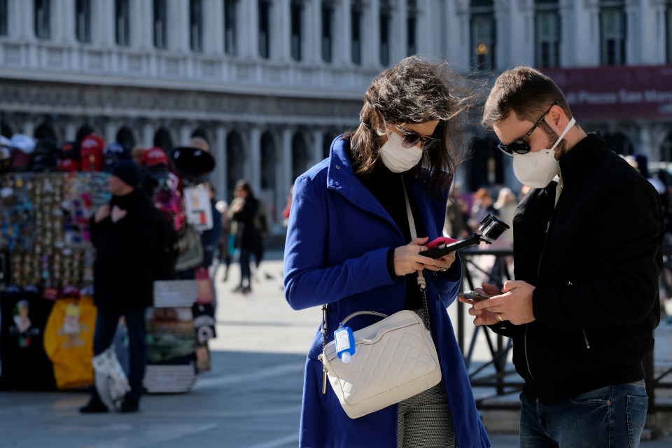 Tourists wear protective masks in Saint Mark’s Square in Venice