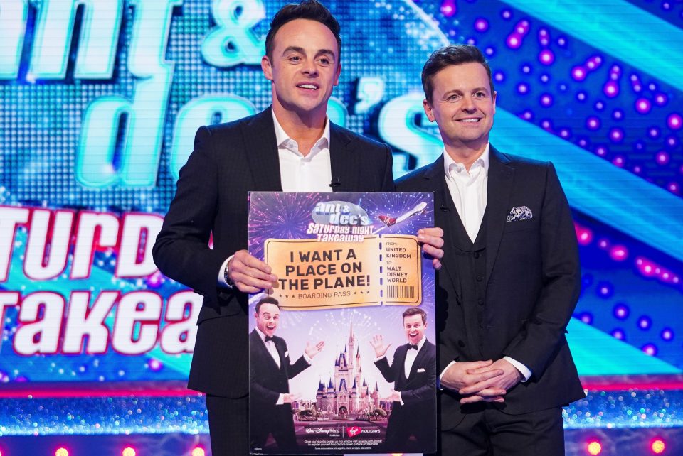  Ant & Dec hold up a prize poster with the Virgin logo visible