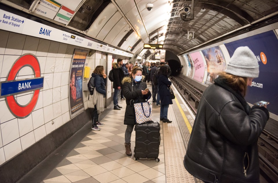 A woman wears a face mask while waiting for a tube train at Bank underground on Sunday