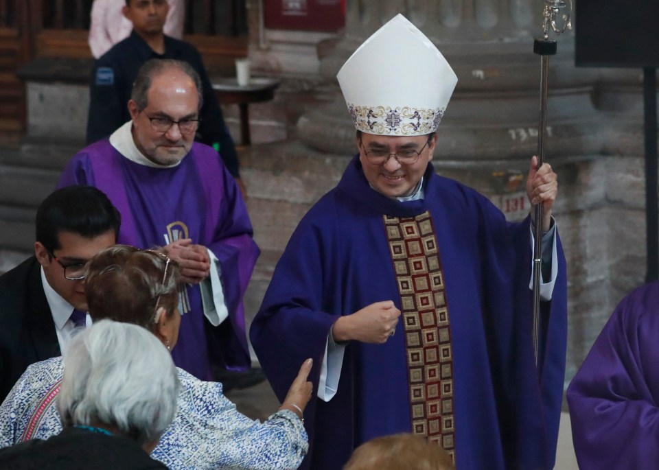 Bishop Gonzalez Morales pulls his hand away from a woman who wanted to kiss it during Sunday Mass in Mexico amid virus fears