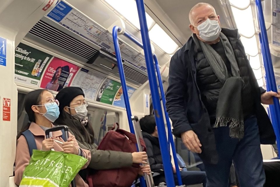  Passengers on the London Underground wear protective masks as they travel