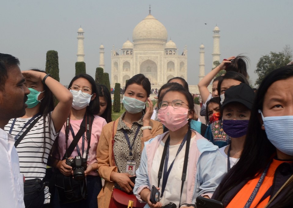  Tourists wearing protective masks are pictured at the historic Taj Mahal in Agra, India