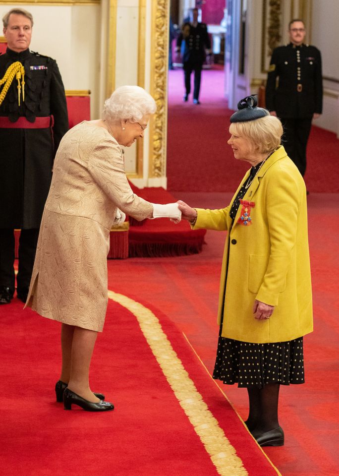  The Monarch covered her hands as she handed out gongs at Buckingham Palace yesterday