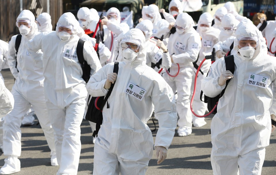  South Korean army soldiers wearing protective gears move to spray disinfectant as a precaution against the new coronavirus in Gyeongan, South Korea