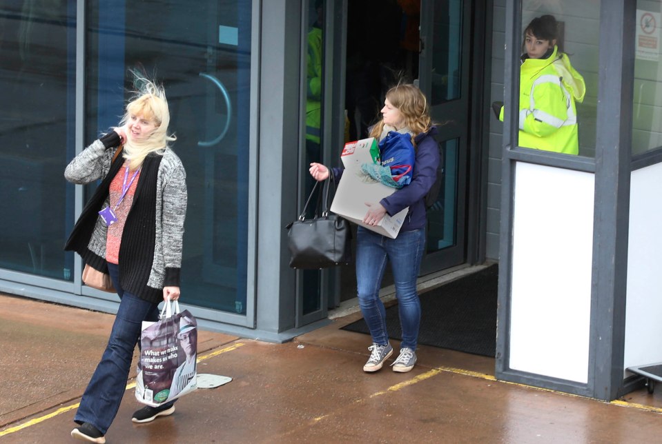  Flybe workers grab hold of their personal possessions as they leave a meeting at the carrier's HQ