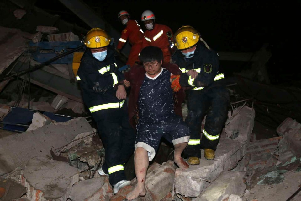 Firefighters rescue a man from the collapsed hotel which was housing quarantined people