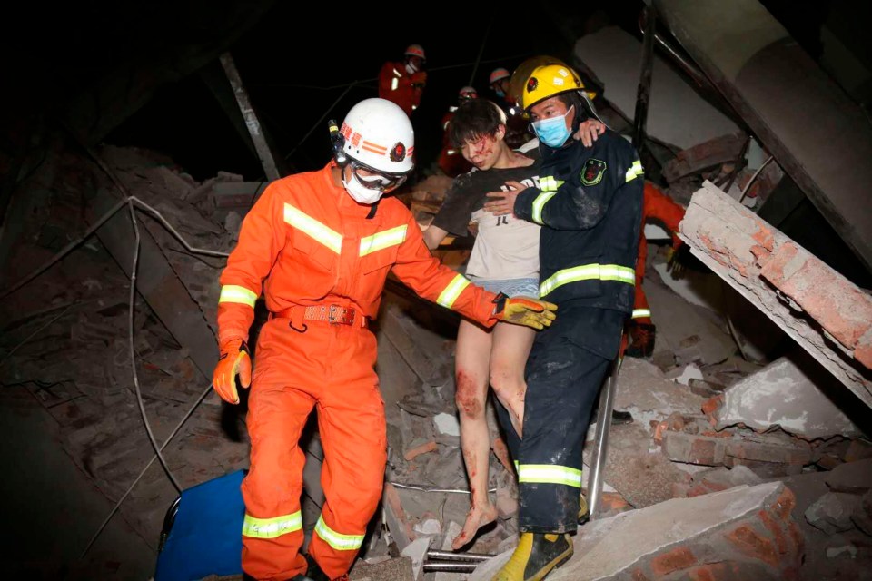 A woman is rescued from the rubble, with 23 still missing