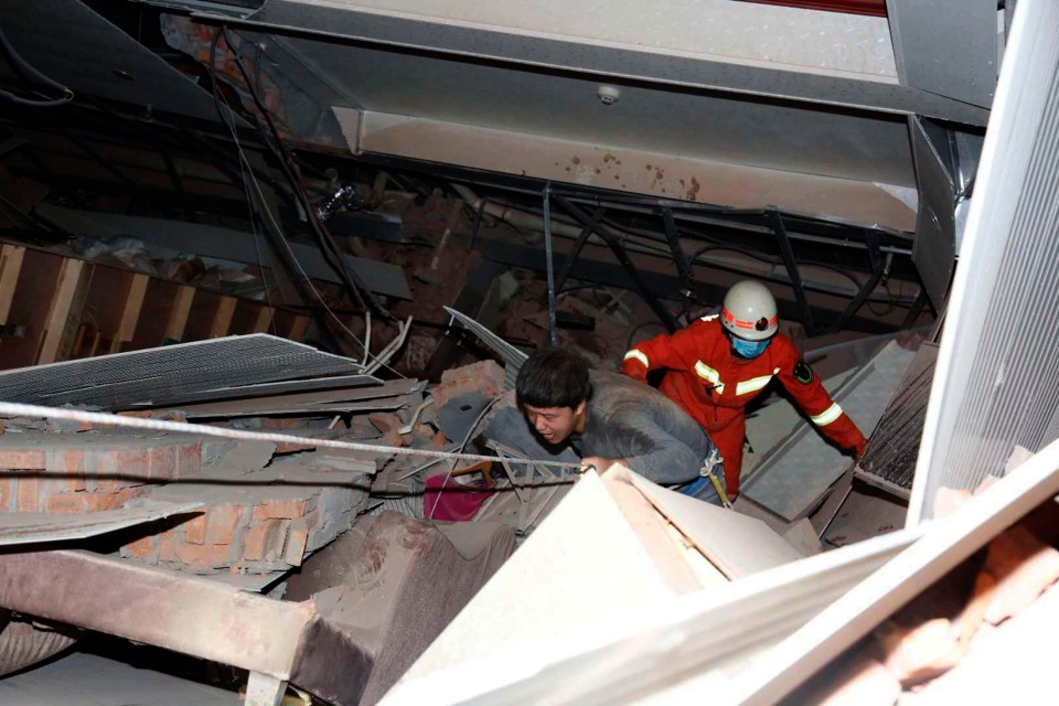 People climb out from the twisted steel of the collapsed facility