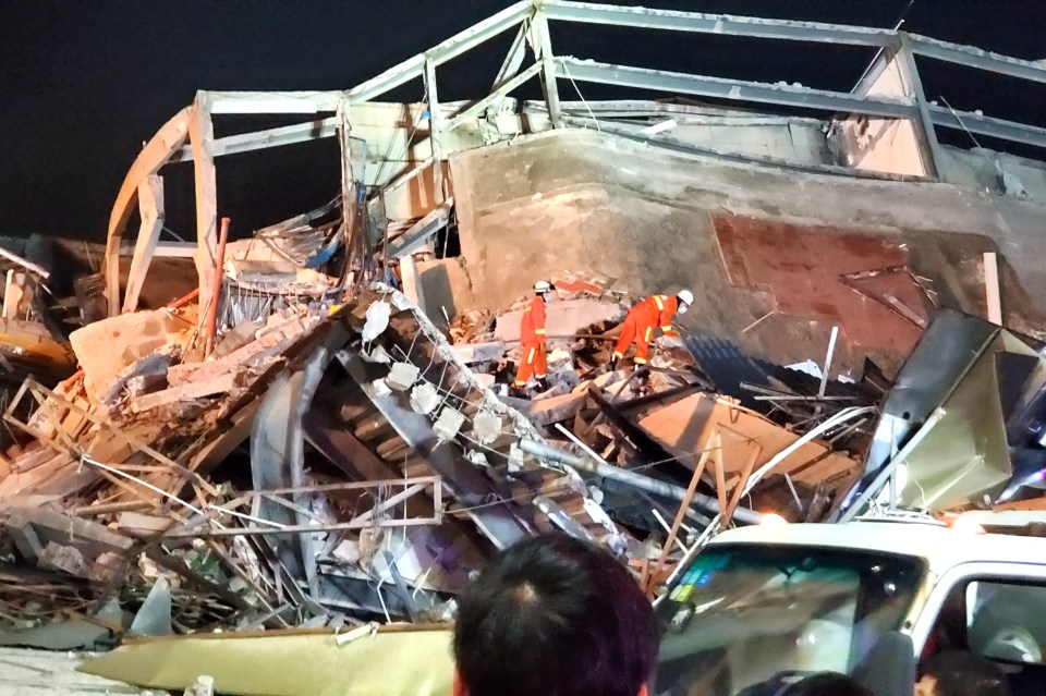 Rescue workers sift through the twisted metal in a bid to find survivors