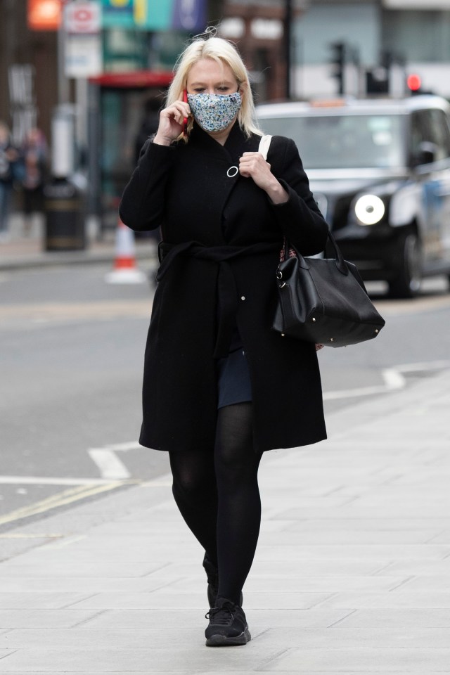 A woman wearing a face mask walks through the normally busy Oxford Street in London