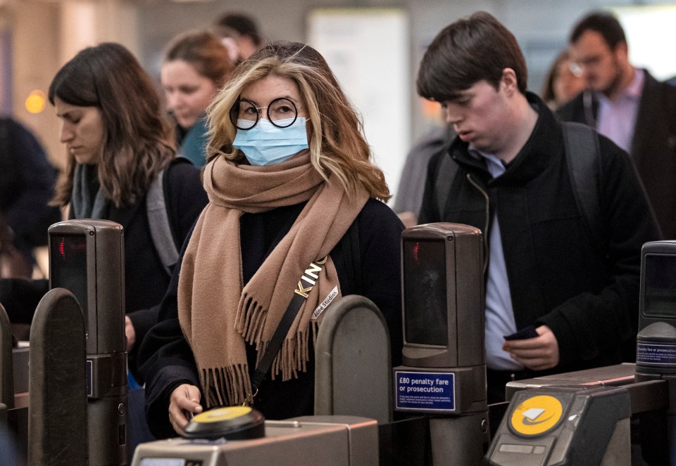  A woman wearing a mask amid the coronavirus fears walks through Westminster Tube station