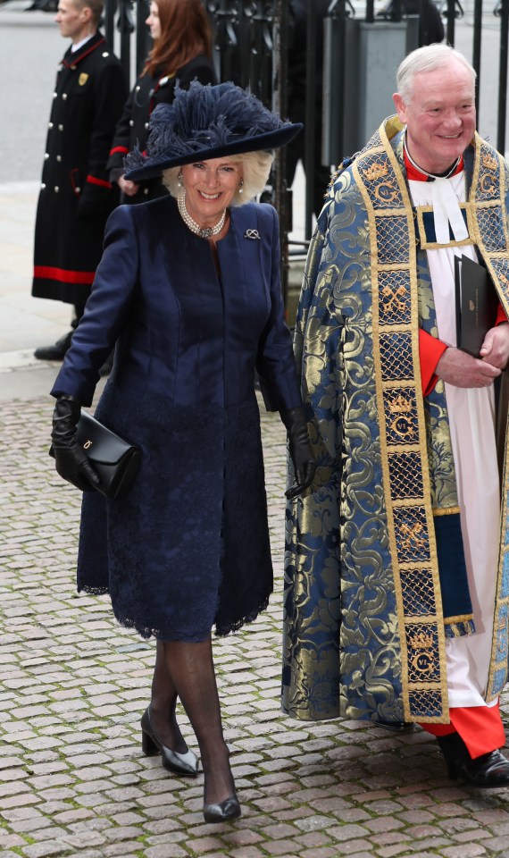 Camilla wore a navy silk and lace dress and coat by Bruce Oldfield and a navy feathered hat by Philip Treacy