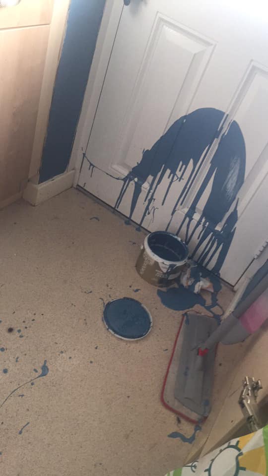  The blue paint was splattered all over the white door and light flooring