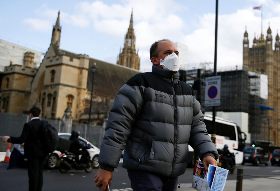  A man wearing a protective face mask is seen outside of the Houses of Parliament