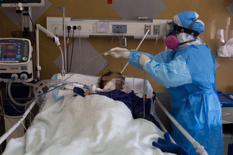 A medic in protective gear treats a patient in Tehran, Iran, last week